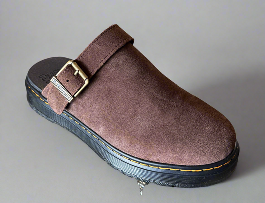 Brown suede slip-on shoe with a buckle on a gray background