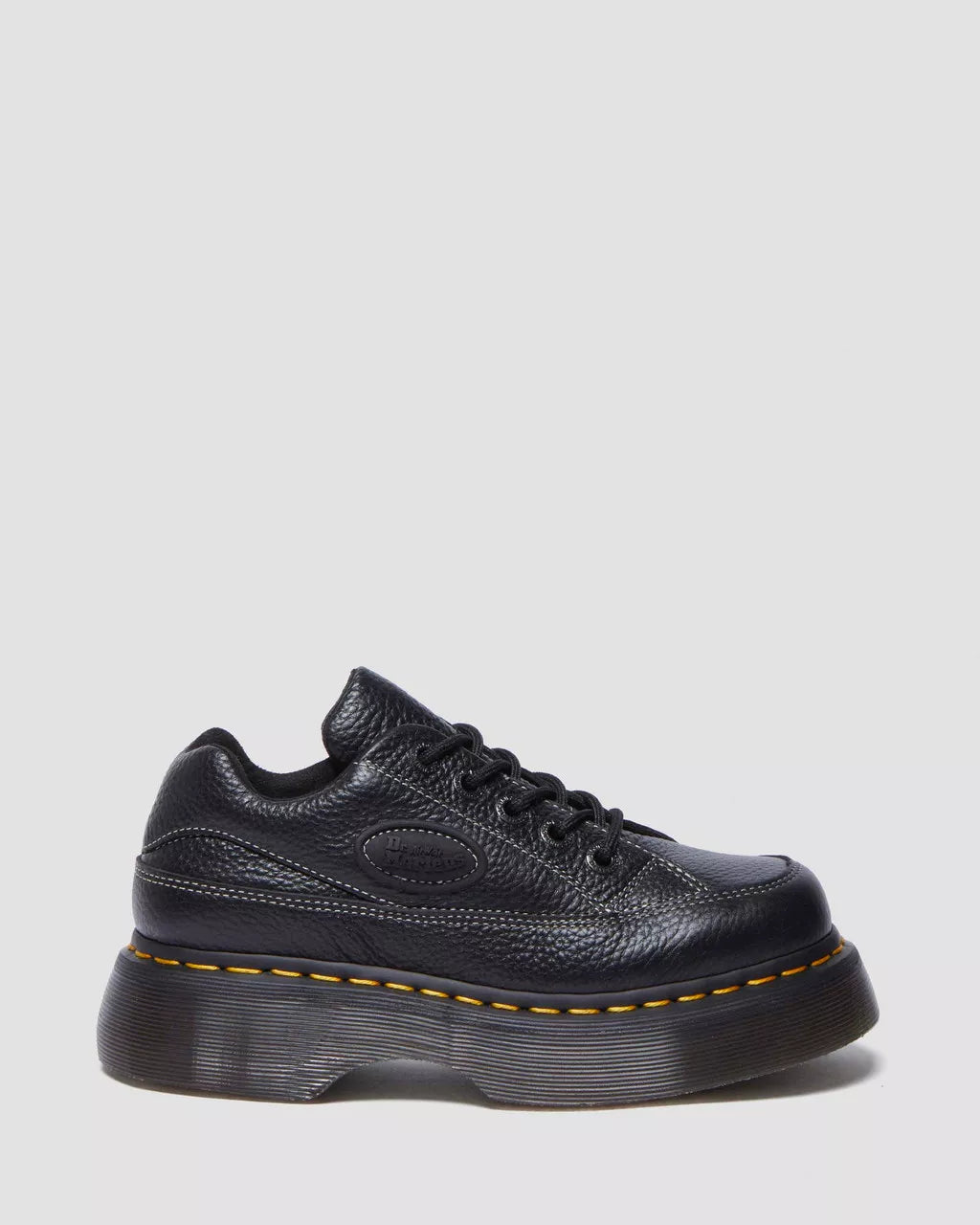 A brown Buzz 5-eye shoe with a lace-up closure and a thick sole.