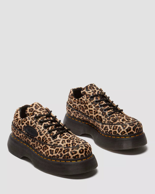 Leopard print shoes with black soles on a light gray background