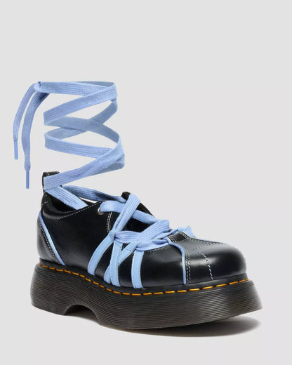 Black platform shoe with blue laces on a light gray background