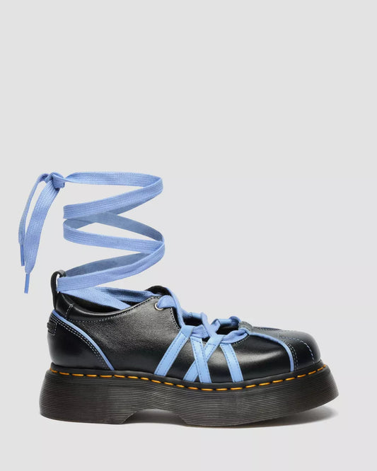 Black shoe with blue laces on a light gray background