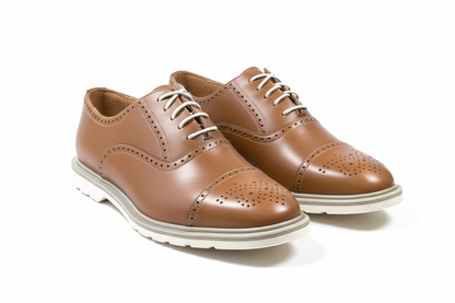 Pair of brown leather shoes with white soles on a white background