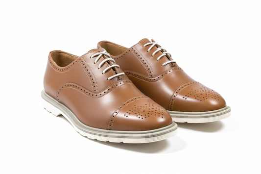 Pair of brown leather shoes with white soles on a white background