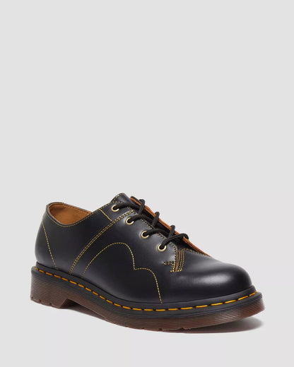 A pair of black smooth leather lace-up shoes with visible stitching on the sole.