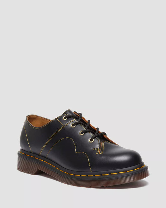 A pair of black smooth leather lace-up shoes with visible stitching on the sole.