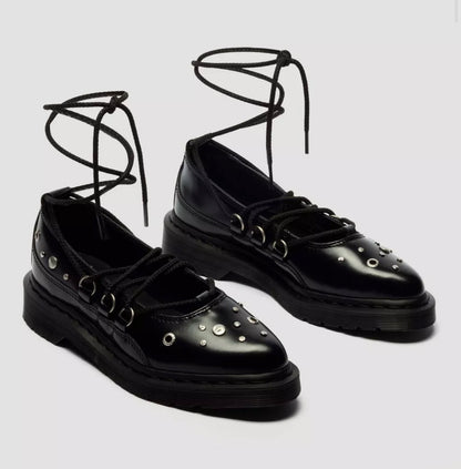 Black lace-up shoes with stud details on a light gray background