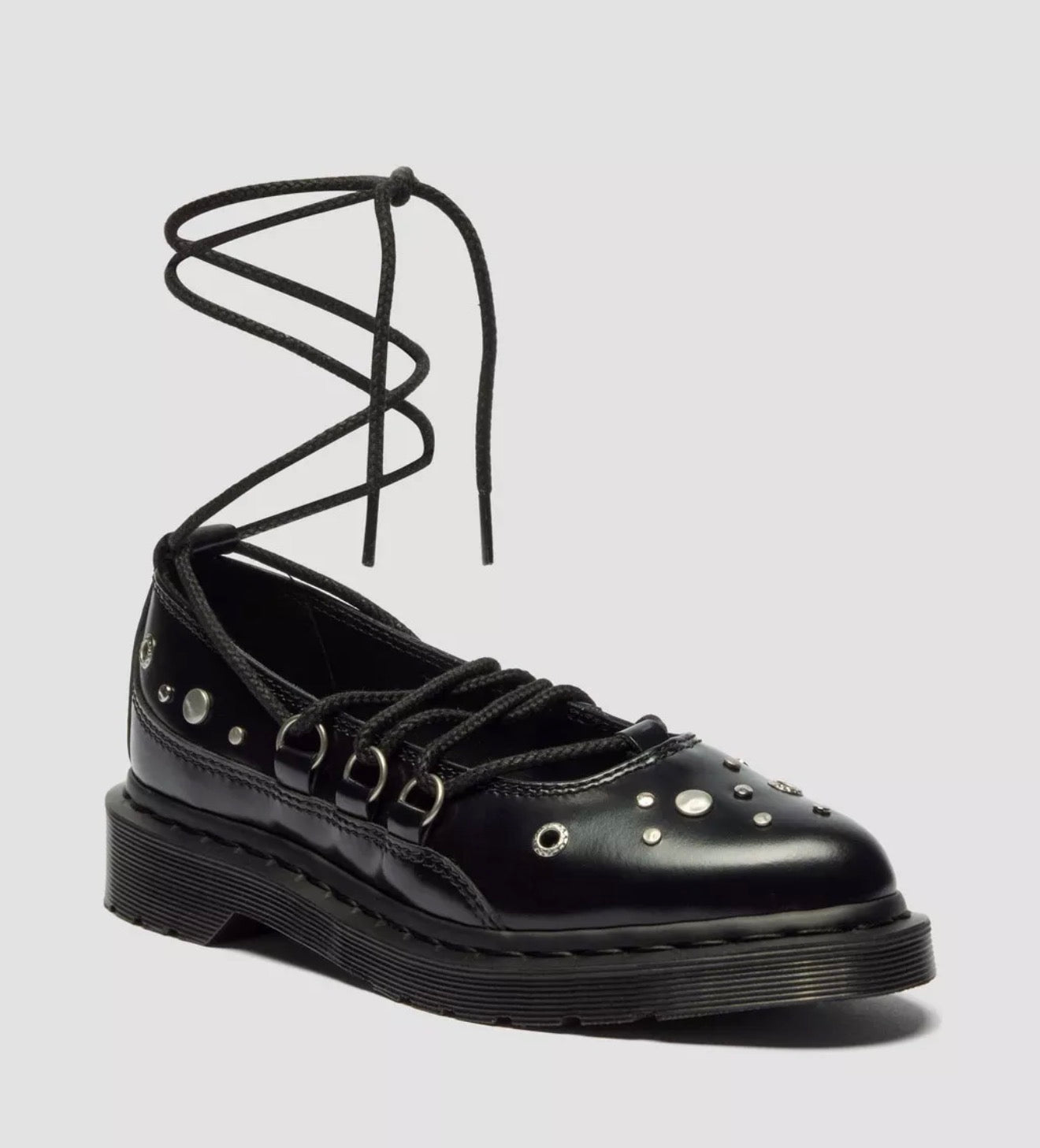 Black leather shoe with unique lace design on a gray background