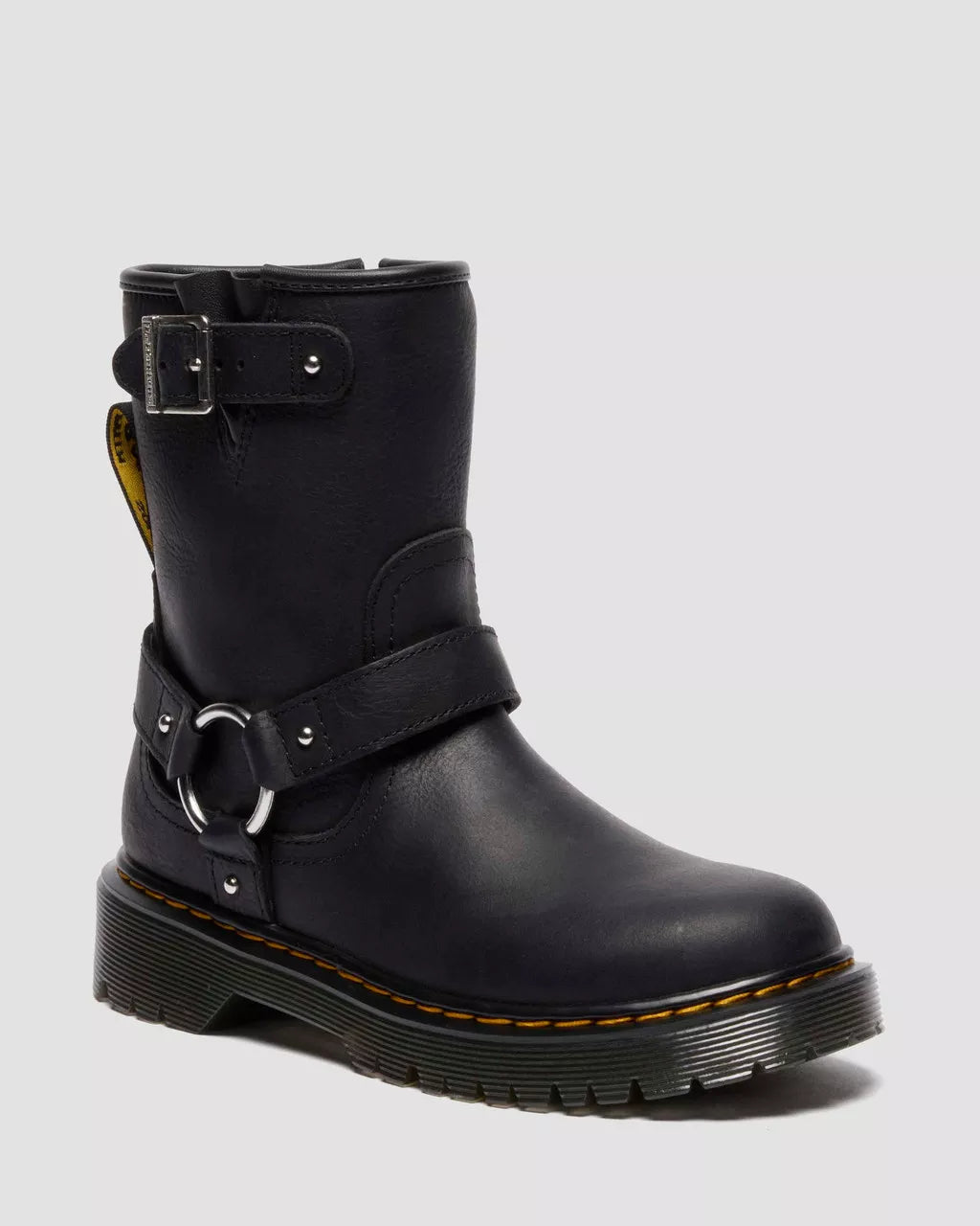 Black leather boot with buckles on a light gray background