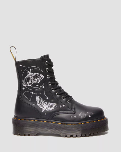 A pair of black Dr. Martens platform boots with embroidered celestial motifs, including stars and moths.