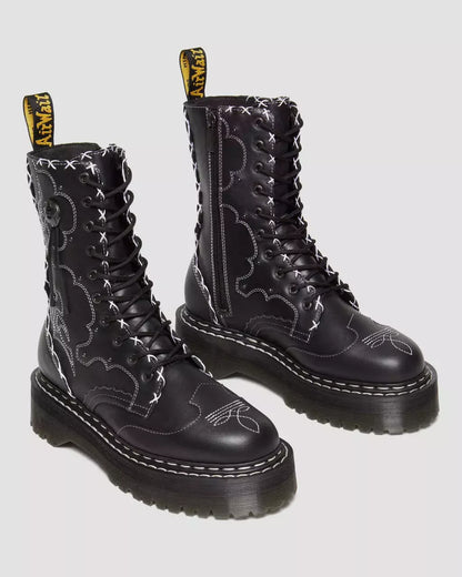 Black leather boots with decorative stitching on a white background