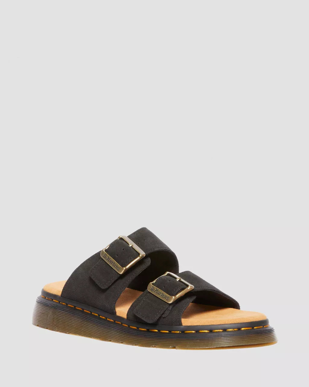 A pair of black suede slide sandals with buckle closures and a flat sole.
