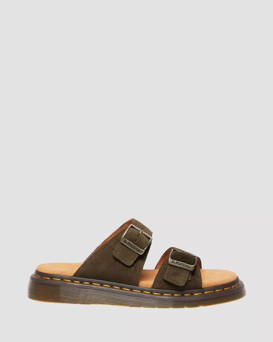 A pair of black suede slide sandals with buckle closures and a flat sole.