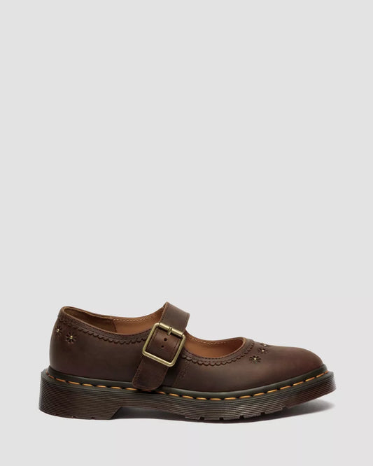 Brown leather shoe with a buckle on a light gray background