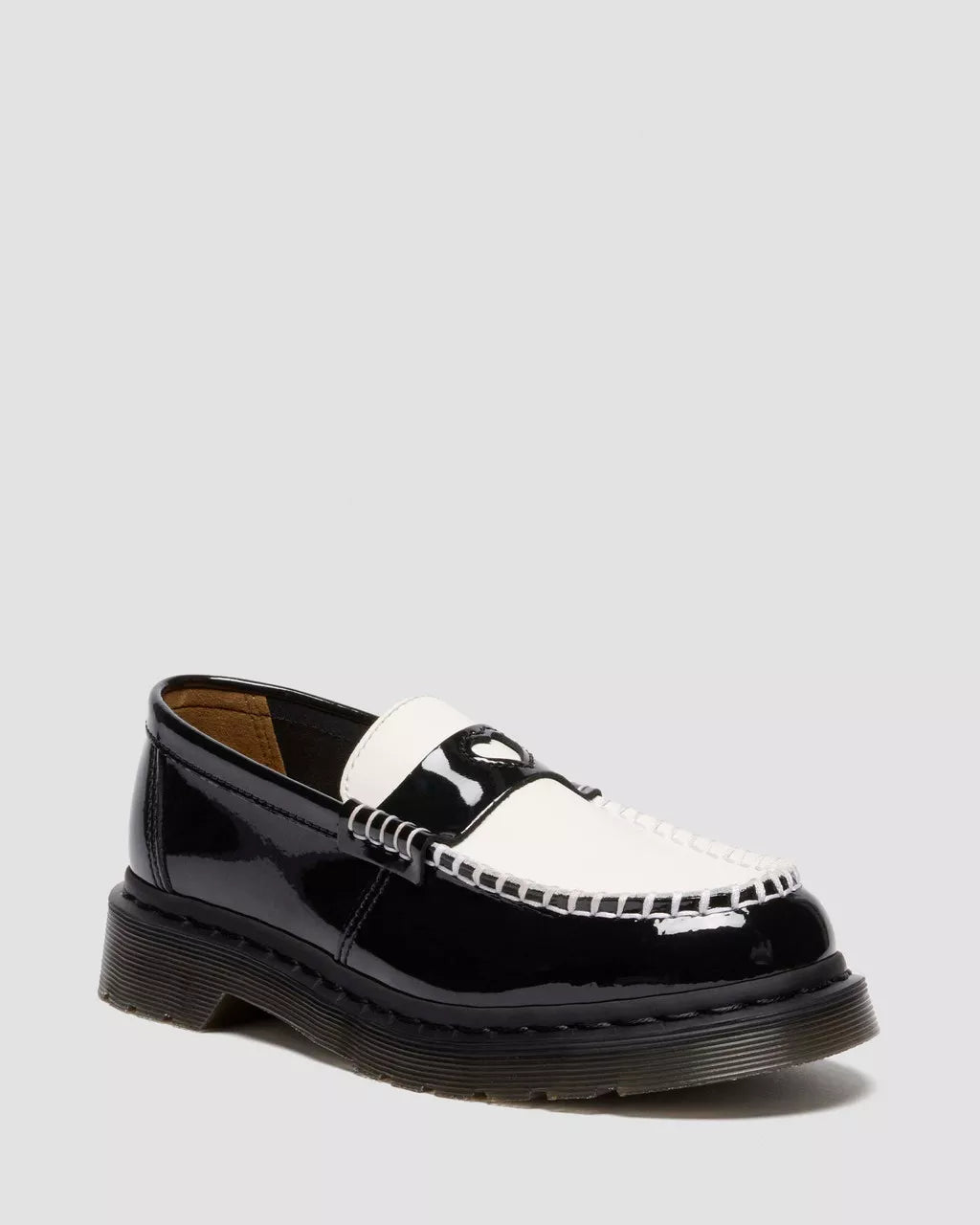 Black and white patent leather loafer on a light gray background
