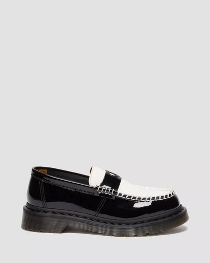 Black patent leather loafer with a silver buckle on a light gray background