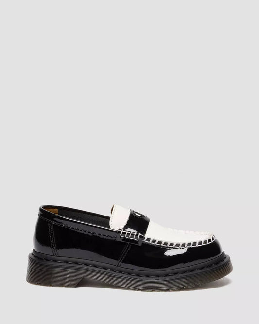 Black patent leather loafer with a silver buckle on a light gray background