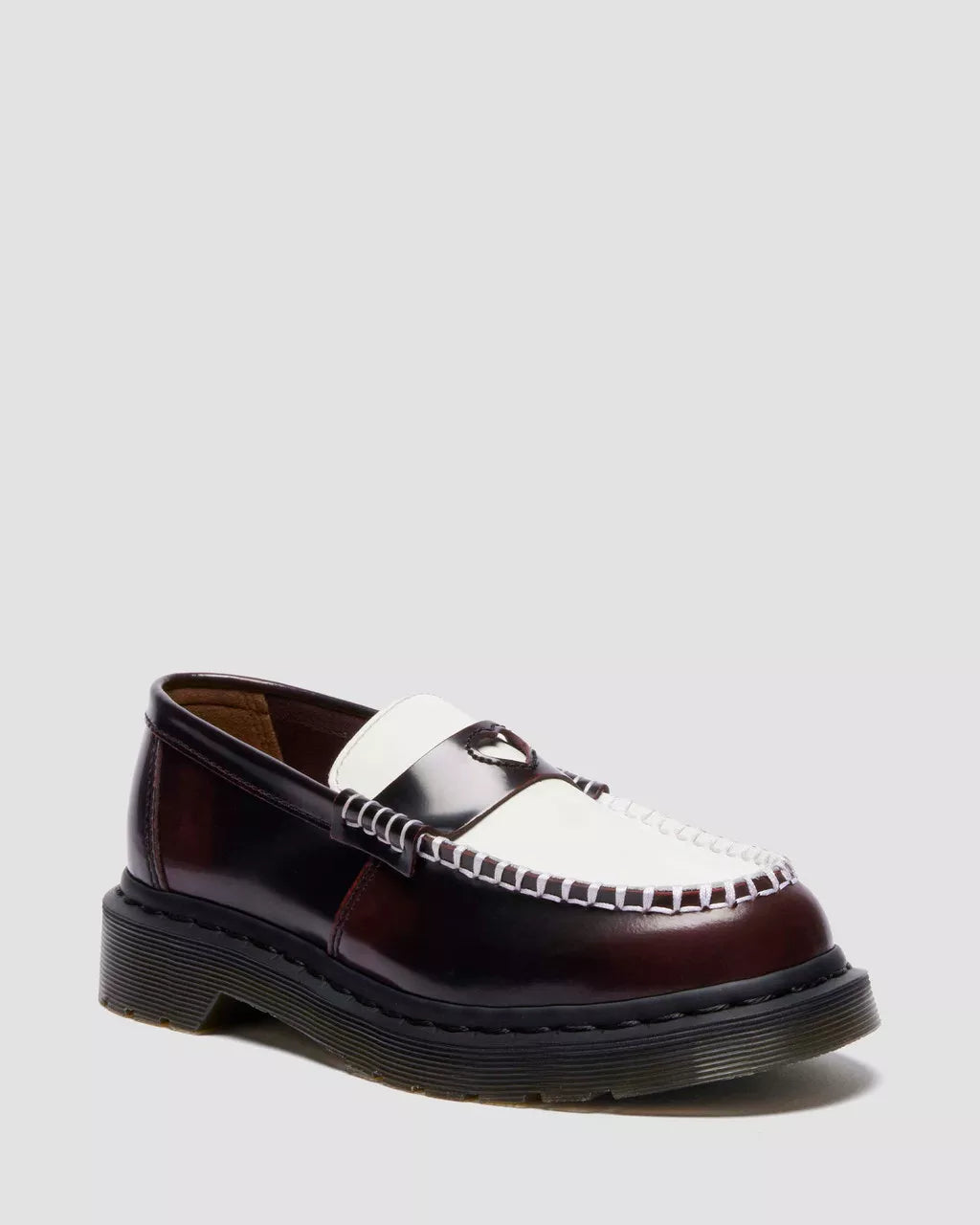 Brown and white loafer shoe on a light gray background