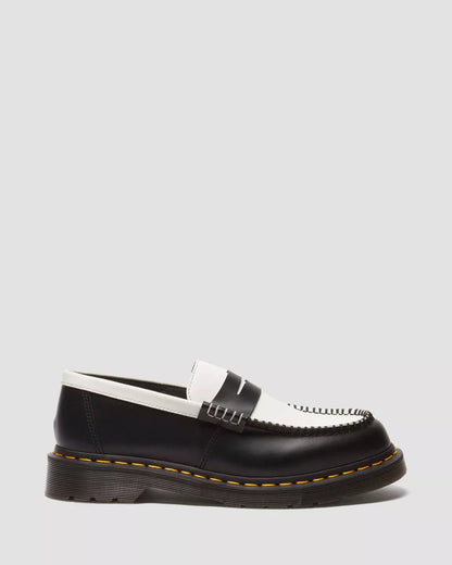 A pair of two-tone smooth leather loafers with a contrast of black and white colors and a distinct stitching detail on the sole.