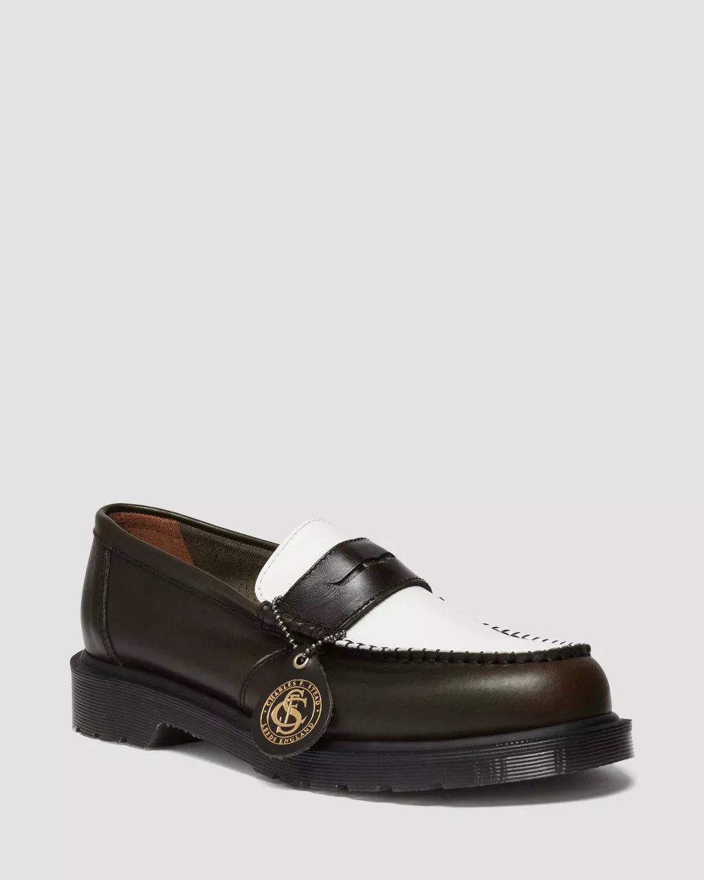 Brown leather loafer with white strap on a white background