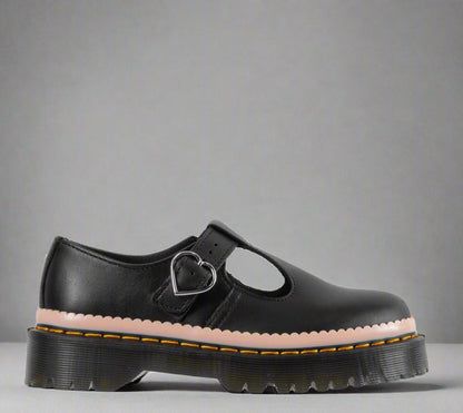 A black sandal with a heart-shaped buckle on the strap and a thick, chunky sole featuring yellow stitching.