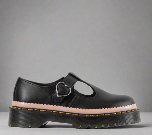 A black sandal with a heart-shaped buckle on the strap and a thick, chunky sole featuring yellow stitching.