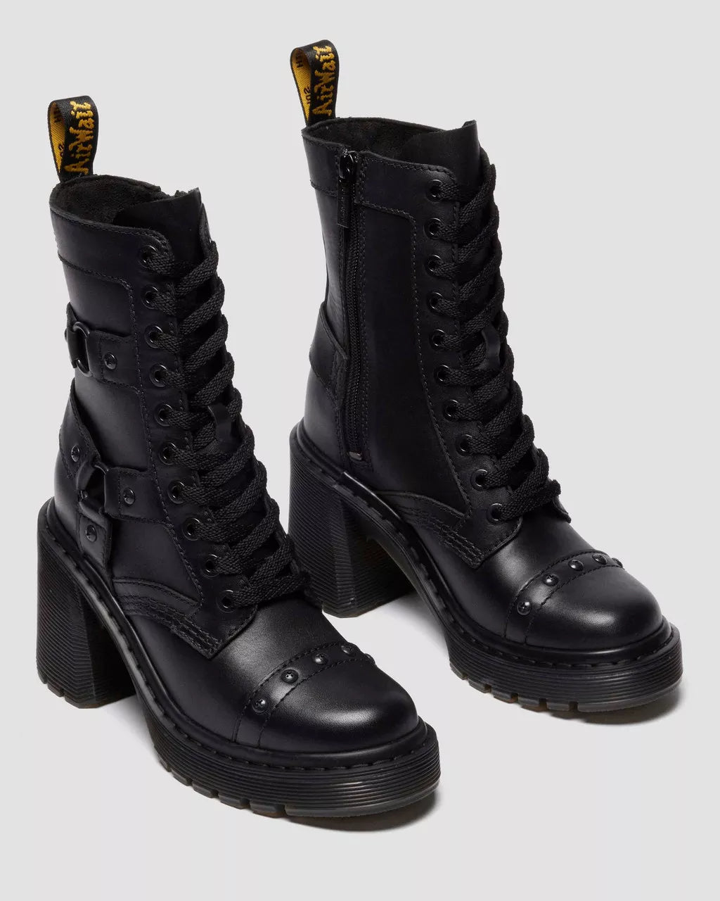 Black leather boots with high block heels on a light gray background