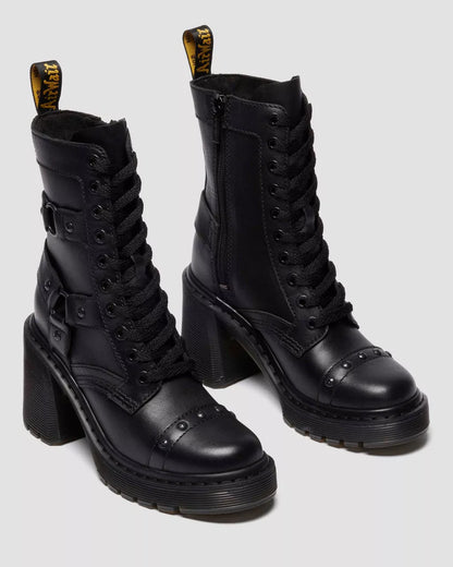 Black leather boots with high block heels on a light gray background