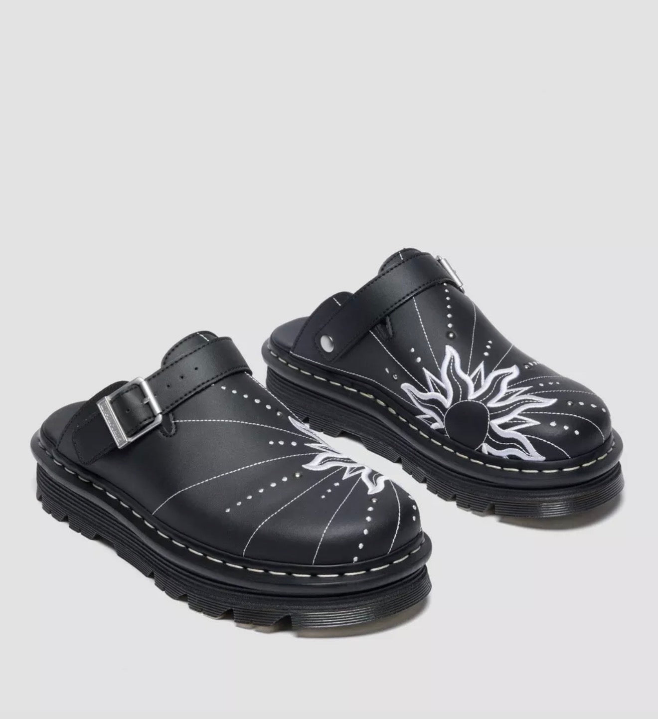 Black clogs with white designs on a light gray background