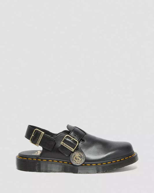 Black leather sandal with gold buckles on a light gray background