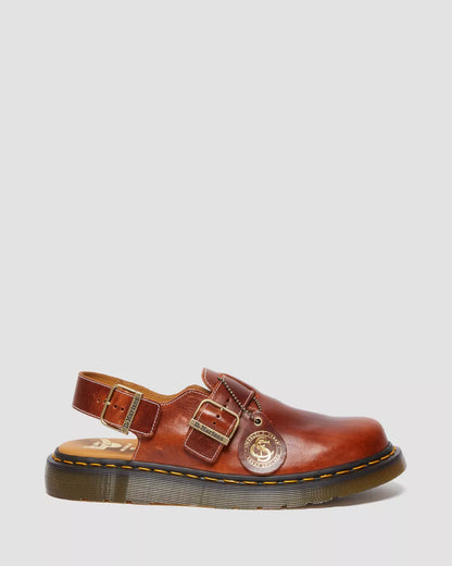 Brown leather shoe with buckles on a light gray background