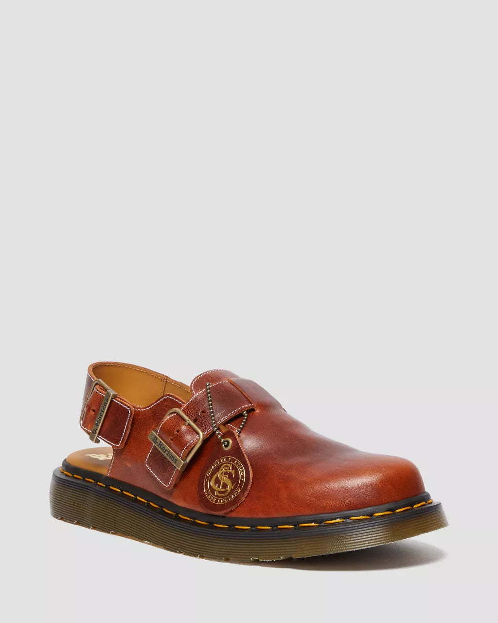 Brown leather shoe with buckles on a light gray background