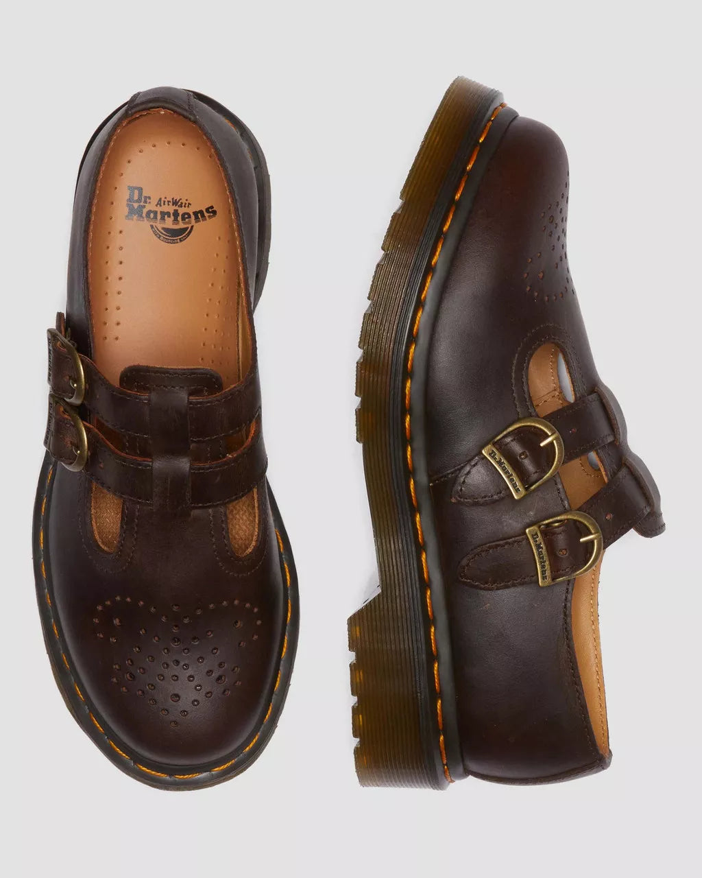 Brown leather shoes with buckles on a light gray background