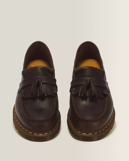 A pair of dark brown leather tassel loafers with yellow contrast stitching and brown soles, photographed from a front-facing angle on a light gray background.