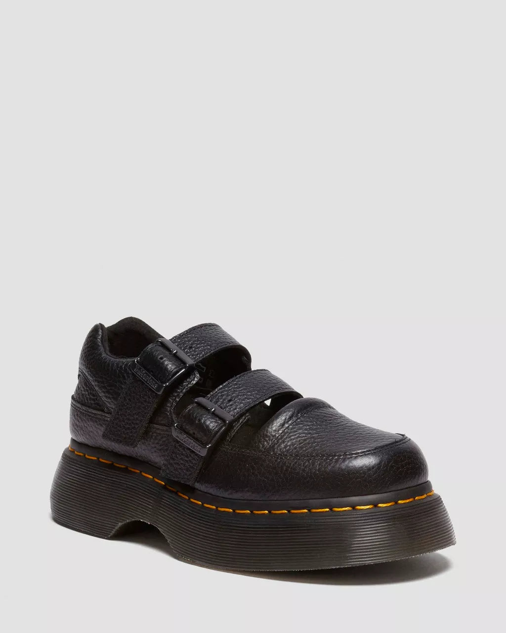 Black leather shoe with velcro straps on a light gray background