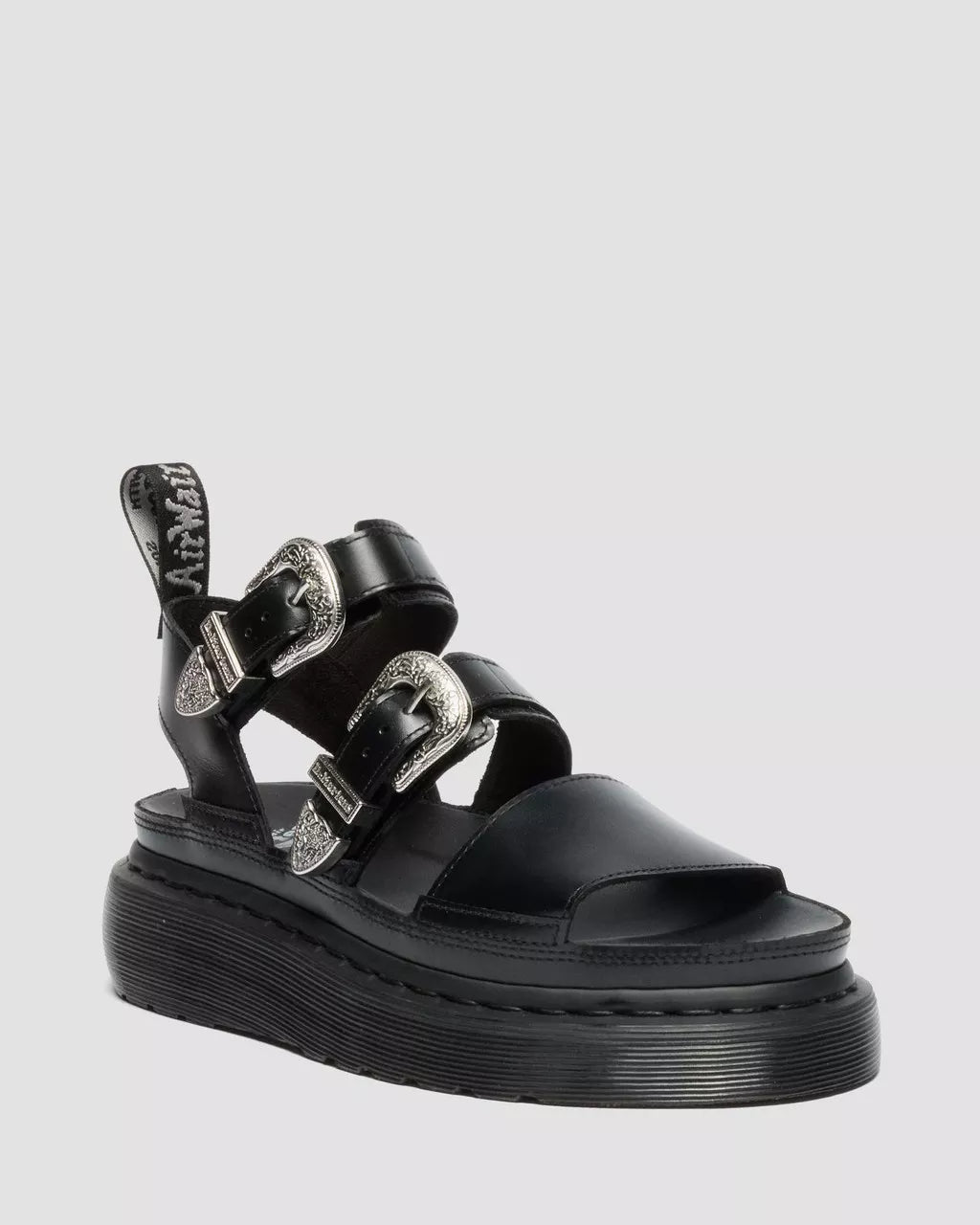Black sandal with multiple straps on a light gray background