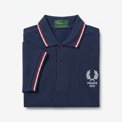 Fred Perry vintage world cup France twin--tipped navy blue polo shirt with white logo and text on a light gray background