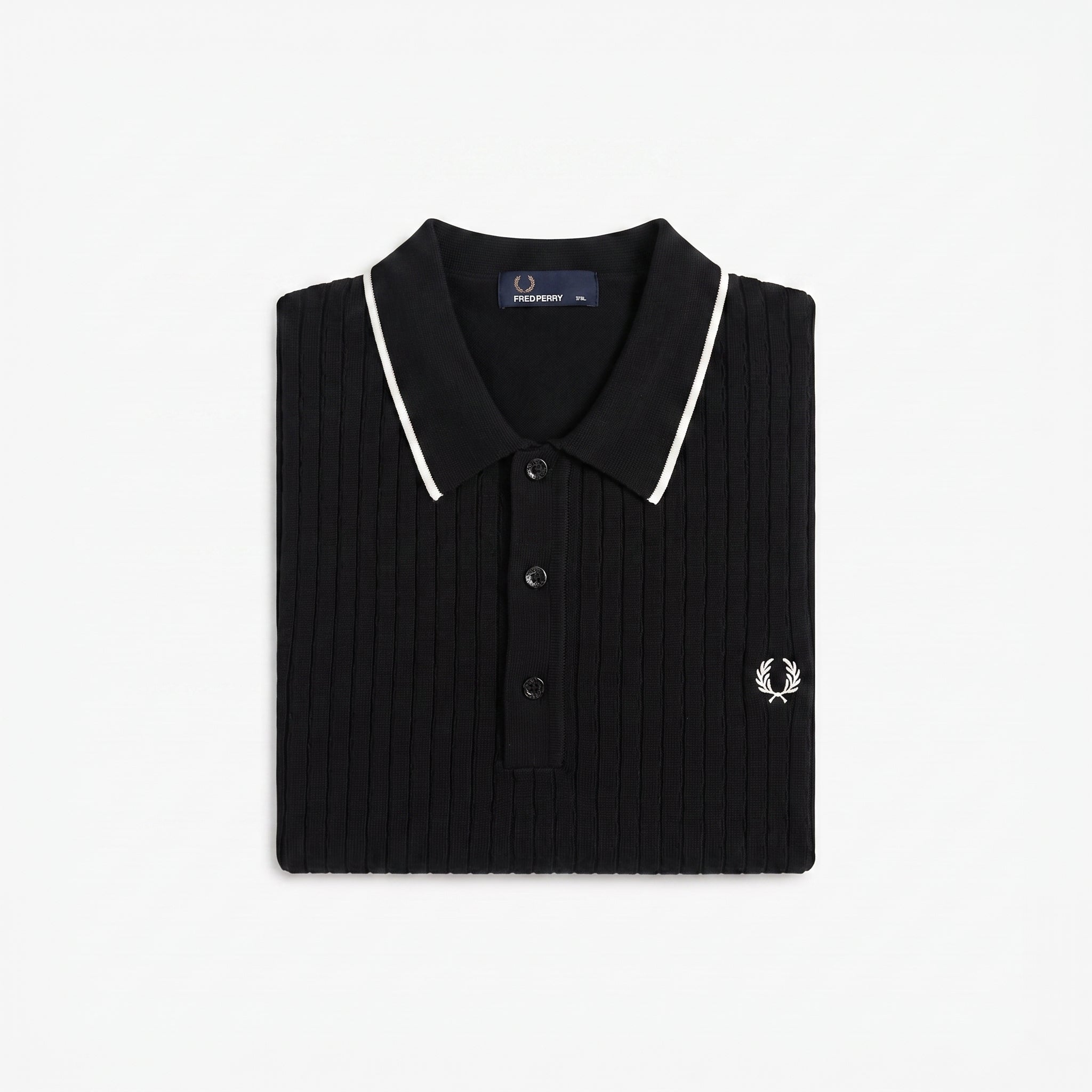 A folded black ribbed knit polo shirt by Fred Perry, featuring white piping along the collar and a small embroidered white logo on the chest, set against a plain white background.