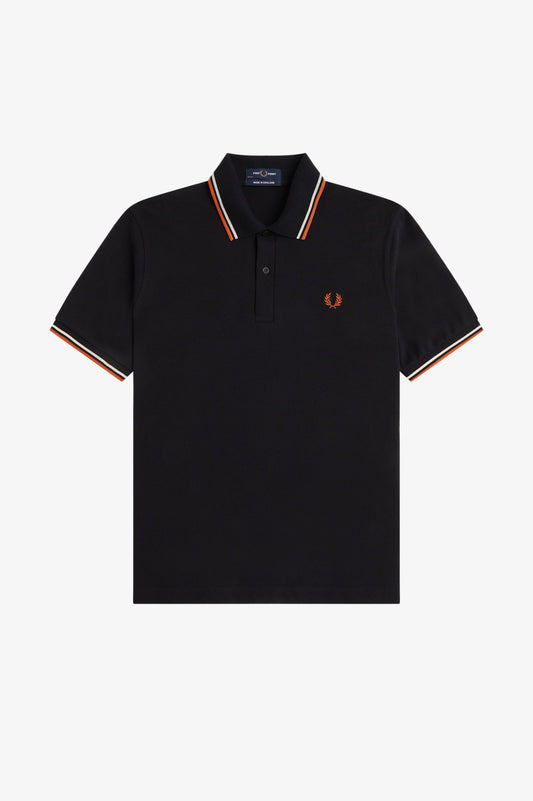 A black short-sleeve polo shirt by Fred Perry, featuring a classic collar with orange, white, and navy blue stripes, and the signature embroidered orange laurel wreath logo on the left chest, displayed against a clean white background.