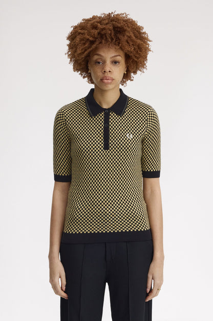 Person wearing a patterned shirt with black collar and trim on a white background