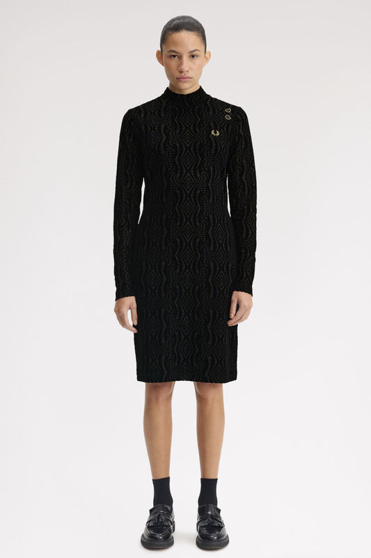 Person wearing a black cable knit dress on a white background