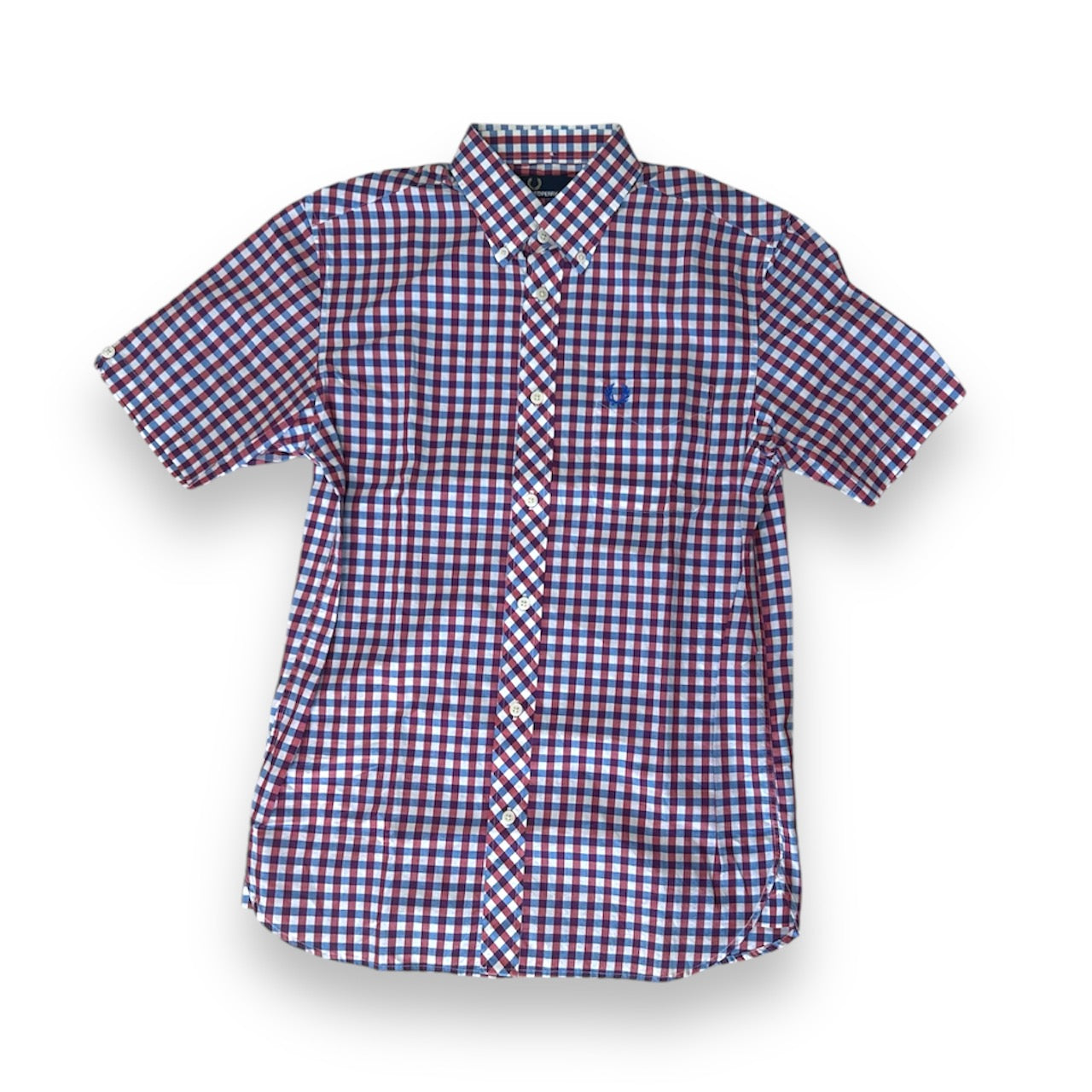 A Fred Perry 3 Color Gingham Shirt with a collar, short sleeves, and a front pocket, featuring a red and blue checkered pattern.