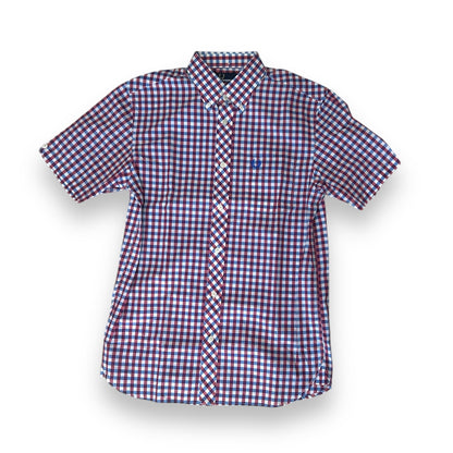 A Fred Perry 3 Color Gingham Shirt with a collar, short sleeves, and a front pocket, featuring a red and blue checkered pattern.