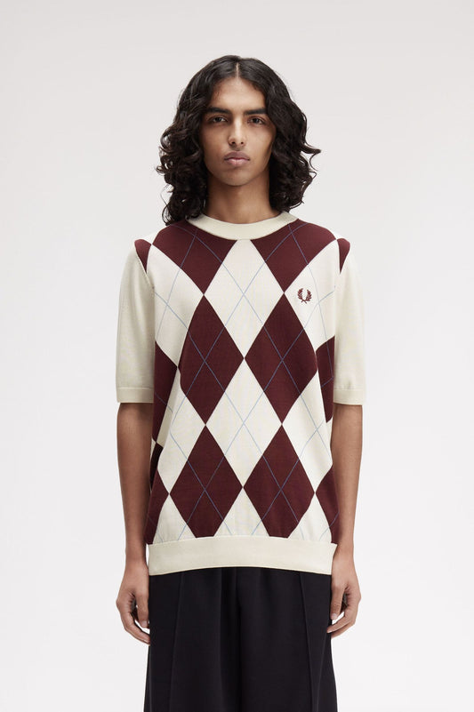 Person wearing a maroon and white argyle sweater on a plain background