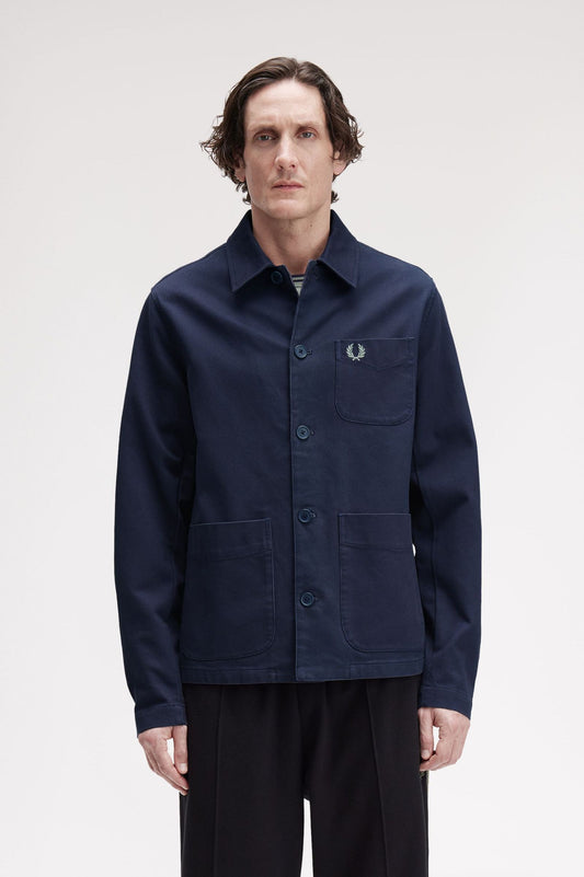 Man wearing a navy jacket with a brand logo on a white background