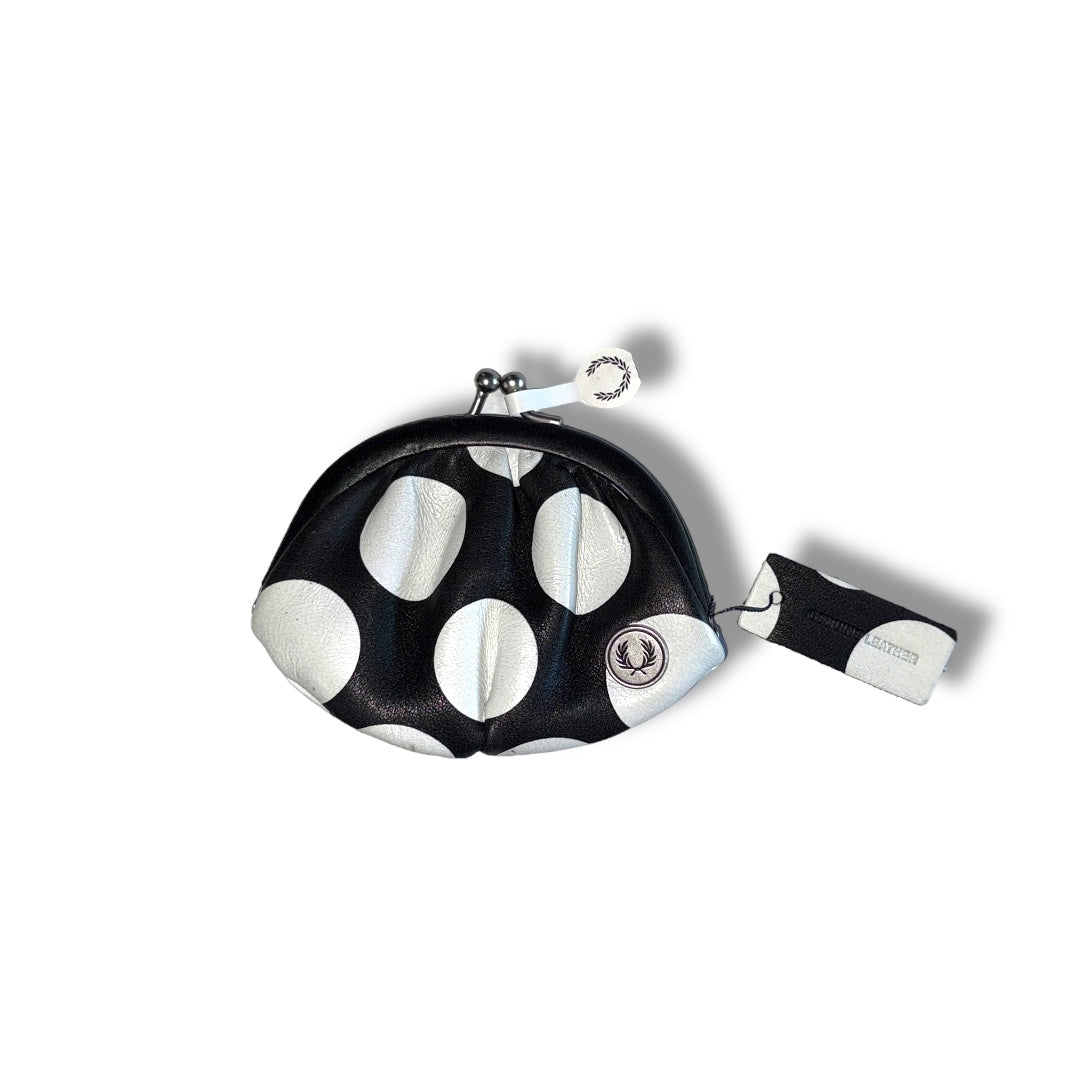 A shell-shaped coin purse with a black and white polka dot design and a Fred Perry logo.