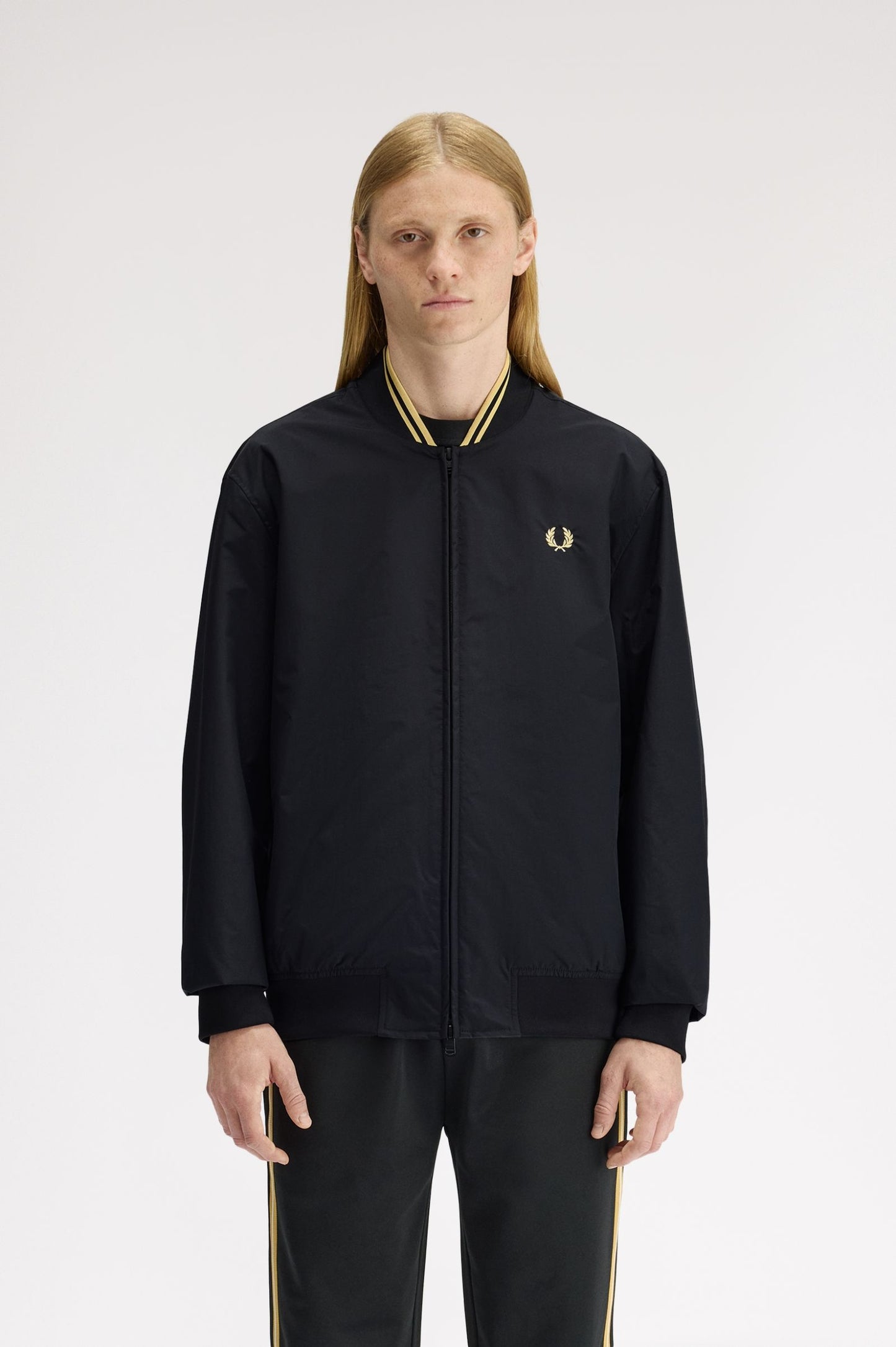 Person wearing a black tracksuit with a brand logo on a white background