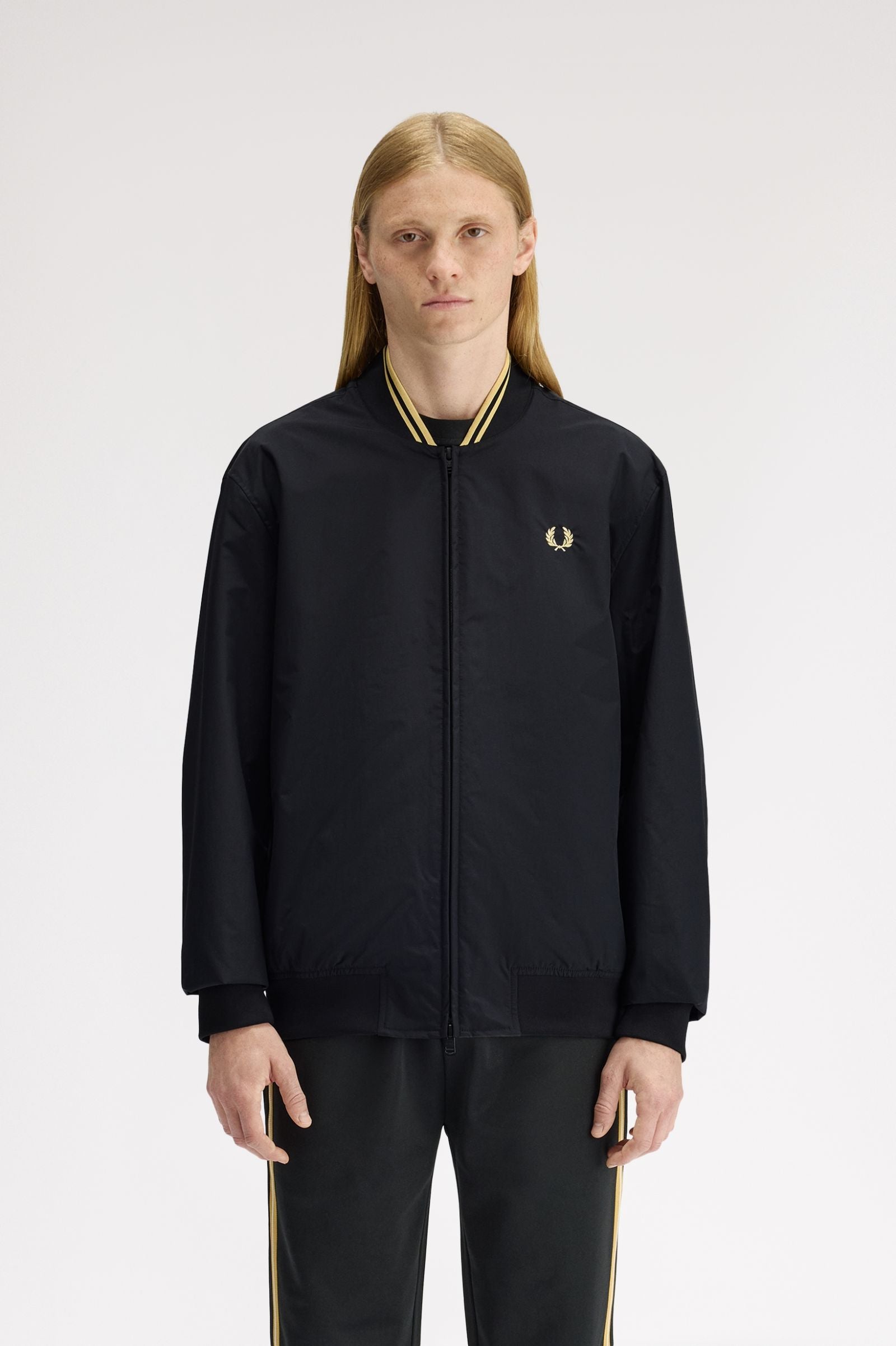 Person wearing a black tracksuit with a brand logo on a white background