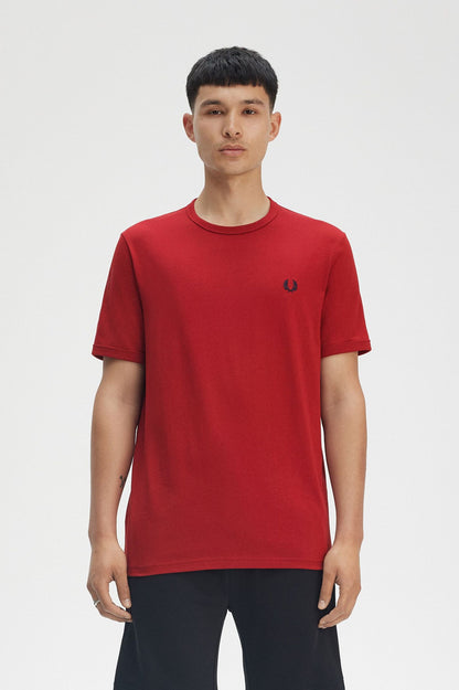 Person wearing a red t-shirt with a brand logo on a white background