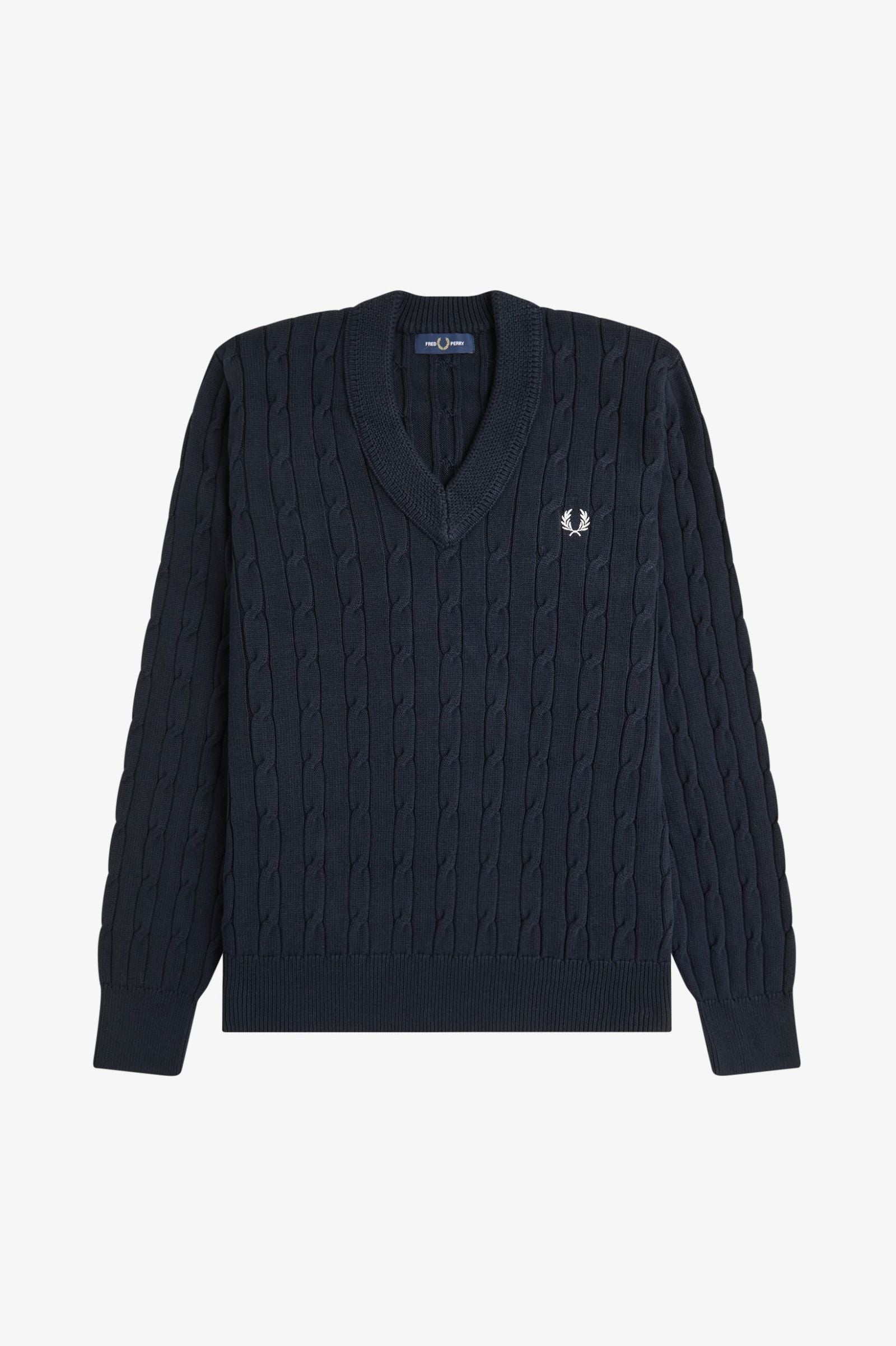 Navy cable knit sweater with a brand logo on a light gray background