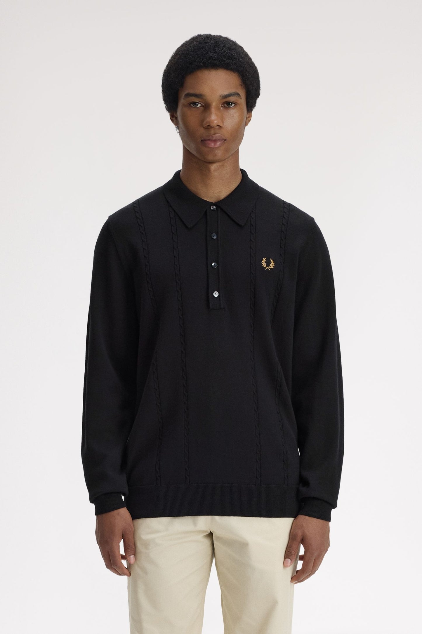 Person wearing a black long-sleeve polo shirt with a brand logo on a white background